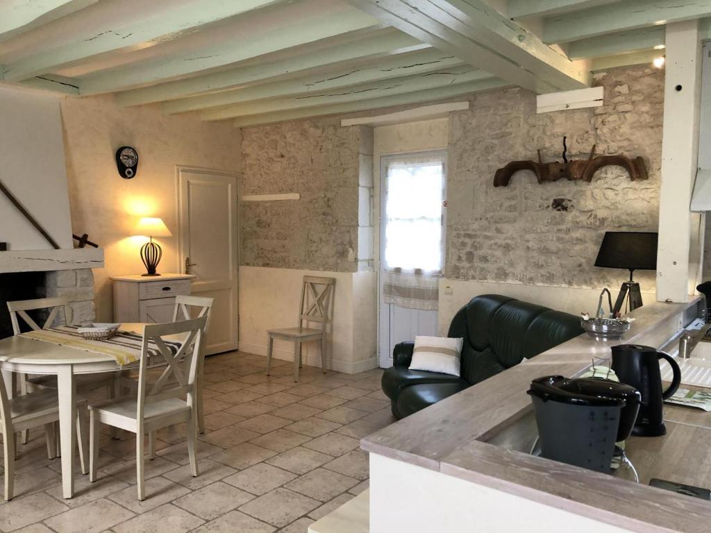 a kitchen and living room with a couch and a table at L'althéa in Saint-Gervais-les-Trois-Clochers