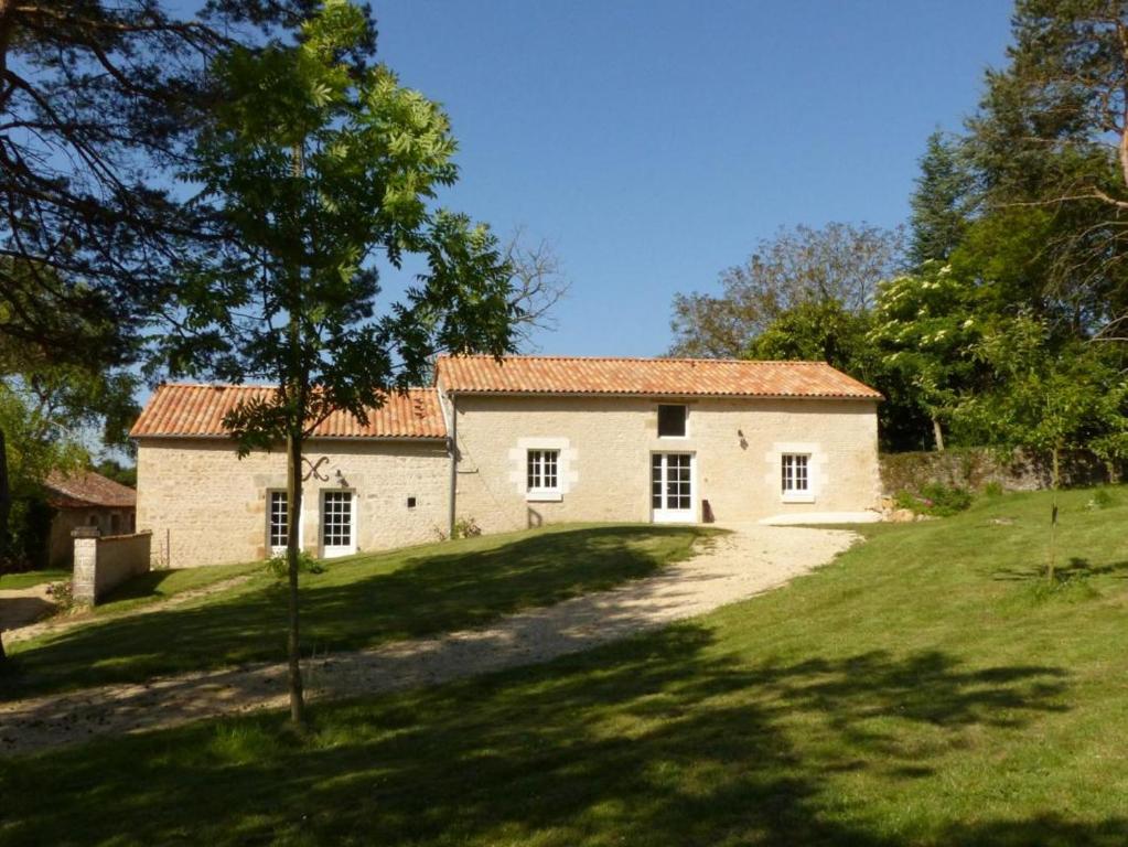a house on a hill with a green yard at Les pierres de la dive in Valence en Poitoux