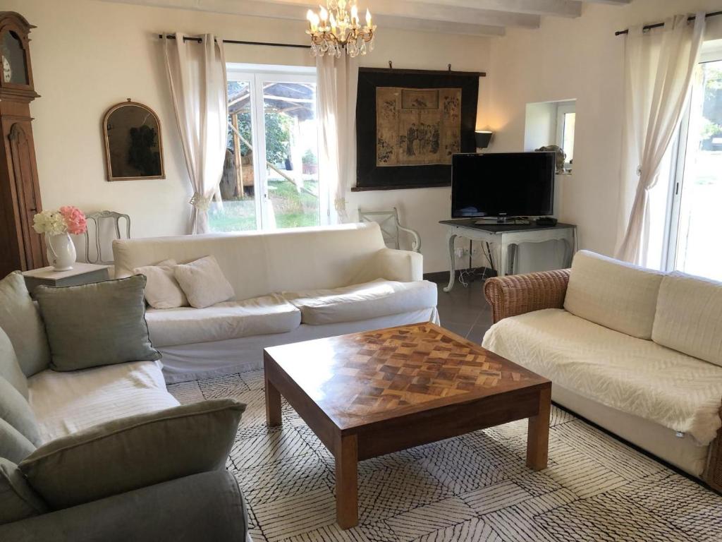 a living room with couches and a coffee table at Le clos constance in Yversay