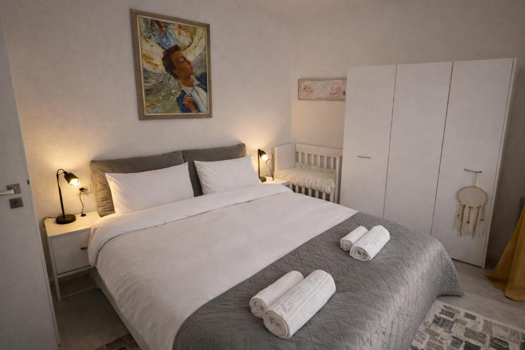 a bedroom with a large bed with two towels on it at Boheme Studio in Timişoara