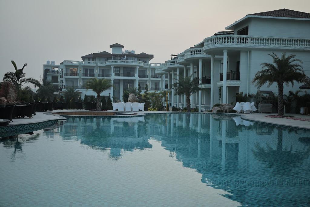a large swimming pool in front of some buildings at Namaste Corbett Resort and Spa in Jāmb