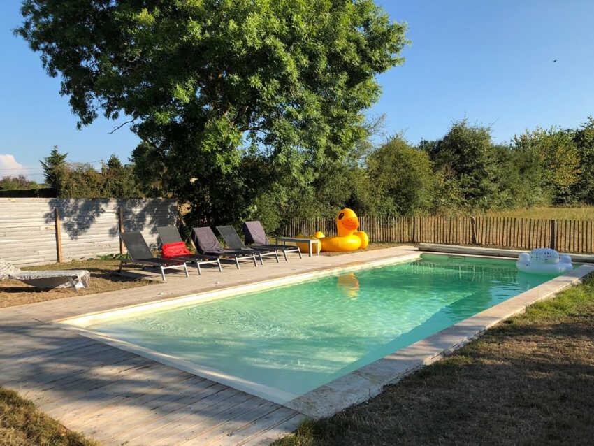 a swimming pool with a toy in a yard at Les tilleuls in Persac