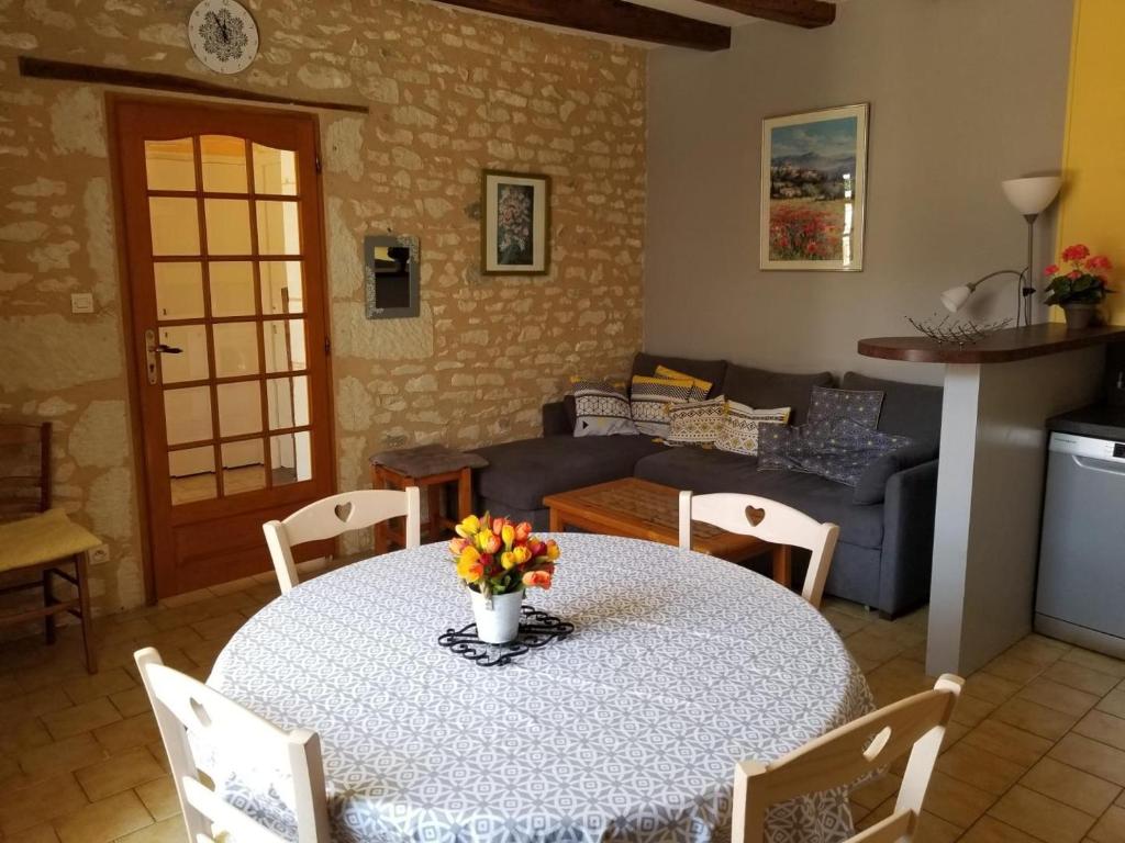 a living room with a table with flowers on it at La maison de gatienne in Coussay-les-Bois