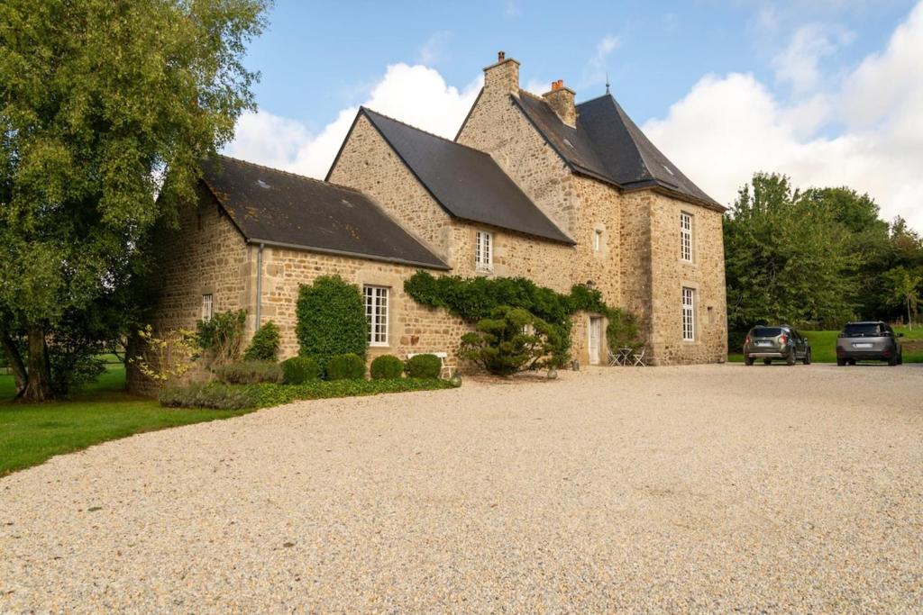 a large stone house with a driveway in front of it at Le Grand Mesnil - Collection Idylliq in Pré-en-Pail