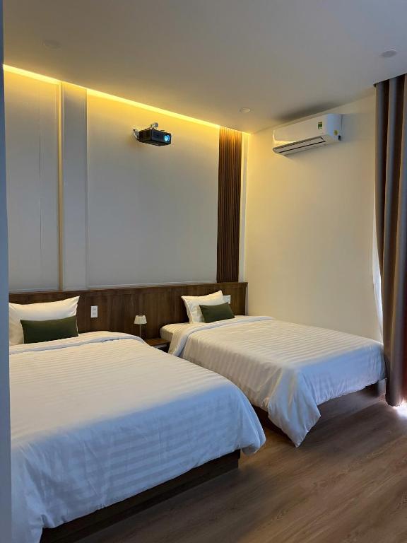 a hotel room with two beds and a window at 19 home in Hue