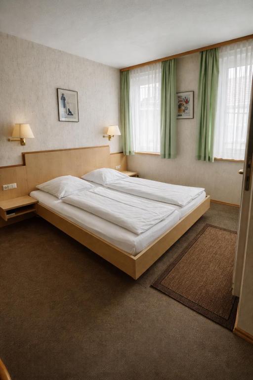a large bed in a bedroom with green curtains at Hotel Ritter in Tuttlingen
