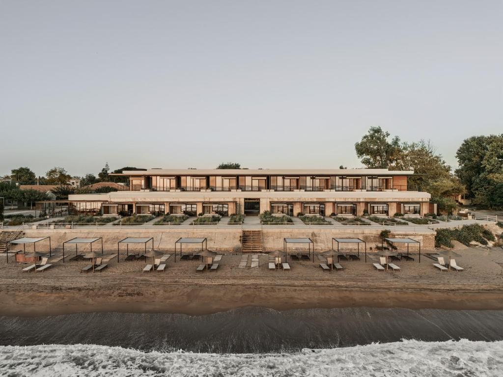 a building on the beach next to the water at Dexamenes Seaside Hotel in Kourouta
