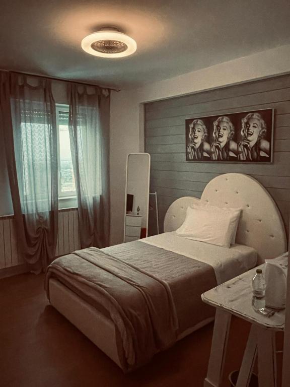 a bedroom with a bed with a poster of women at Aleroom25 in Bari