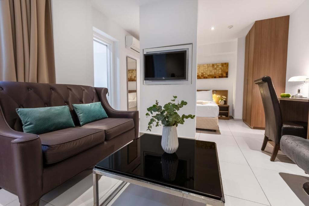 a living room with a couch and a table at Achilleos City Hotel in Larnaca