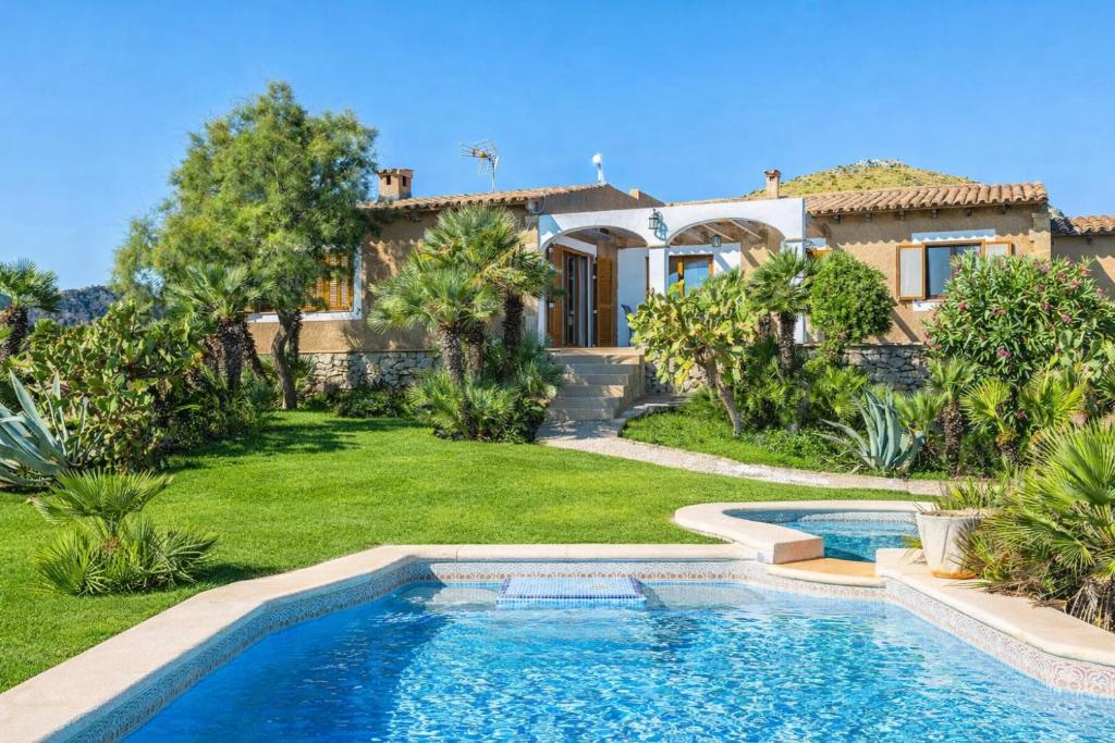 a house with a swimming pool in front of a yard at Ca na Moli in Artá