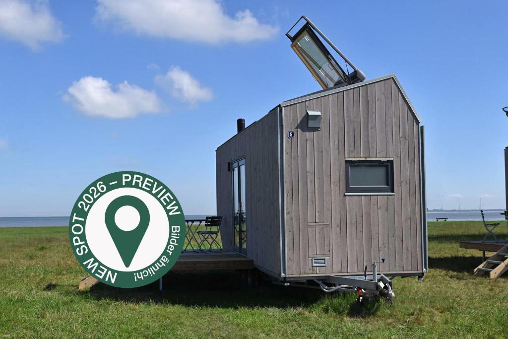 a tiny house sitting on the back of a trailer at Tiny House Pioneer 5 - Green Tiny Spot Schillig in Wangerland