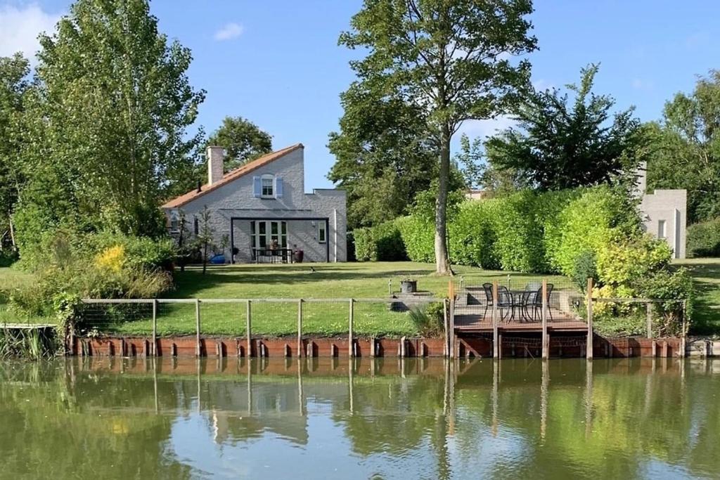 a house with a dock in the middle of a lake at Christoffellaan 101 in Brouwershaven