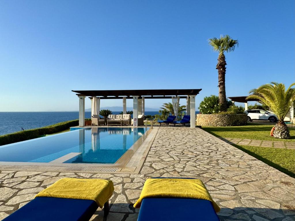 a swimming pool with a gazebo and the ocean at Villa Odysseus Spartia Kefalonia in Spartià