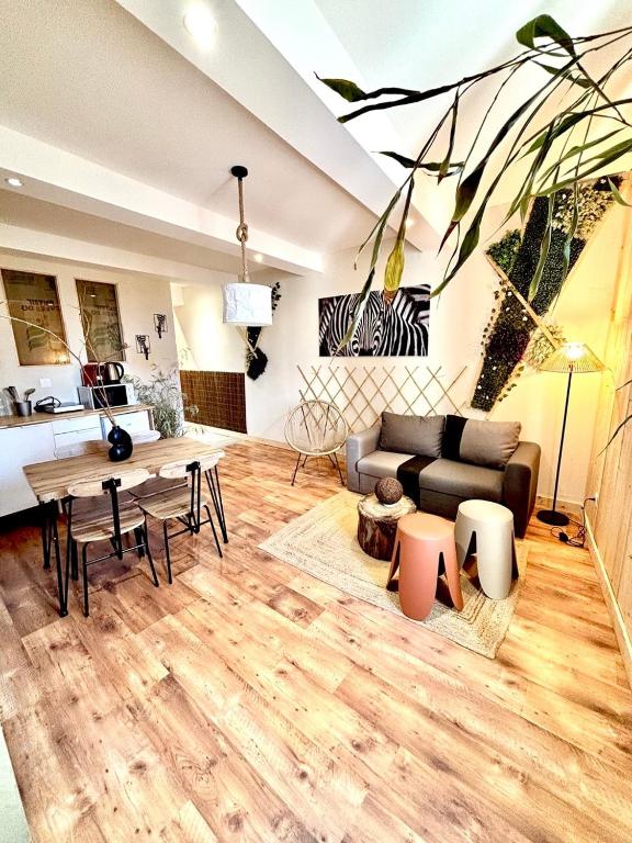 a living room with a couch and a table at Le Safari - Montélimar in Montélimar