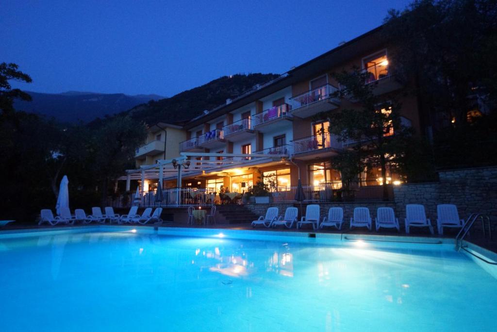 マルチェージネにあるHotel Alpiの夜間のホテル正面のスイミングプール
