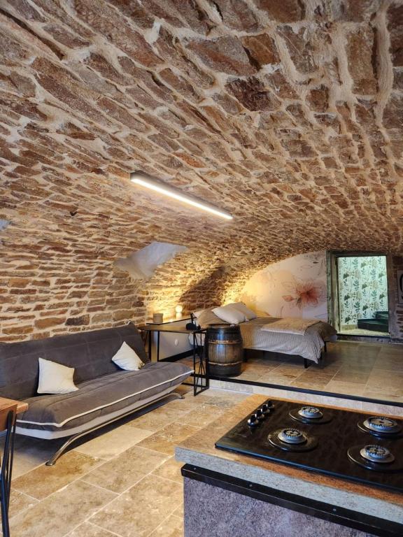 a living room with a couch and a brick wall at Gîte de Burgy in Burgy