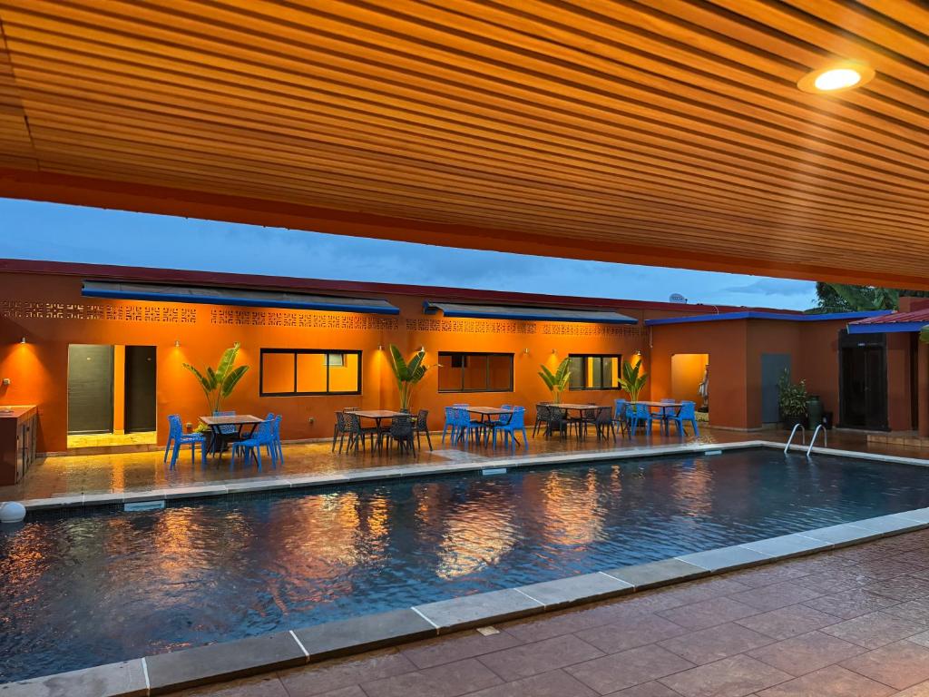 a swimming pool with tables and chairs next to a building at Le Passamainty Lodge in Mamoudzou