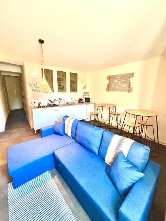 a blue couch in a living room with a kitchen at Le Gouvernail - Montélimar in Montélimar