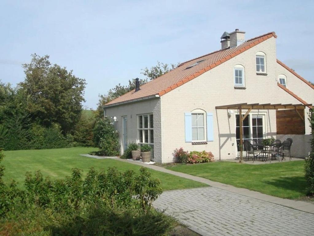 a white house with a patio and a yard at Christoffellaan 72 in Brouwershaven