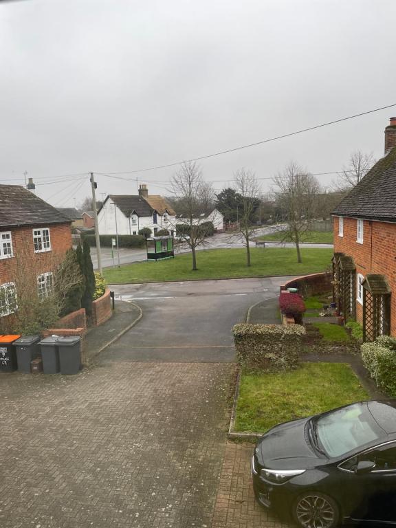 a black car parked in the driveway of a house at Pine Tree Cottage in Linslade