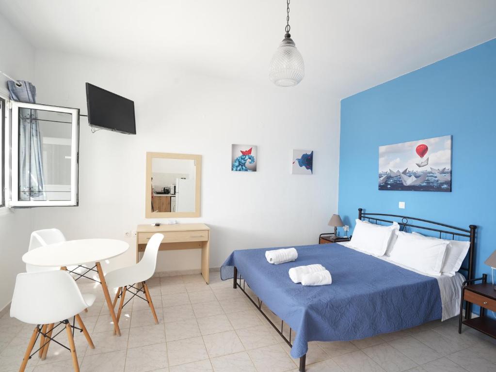 a bedroom with a bed and a table and chairs at Votsalo in Kardamaina