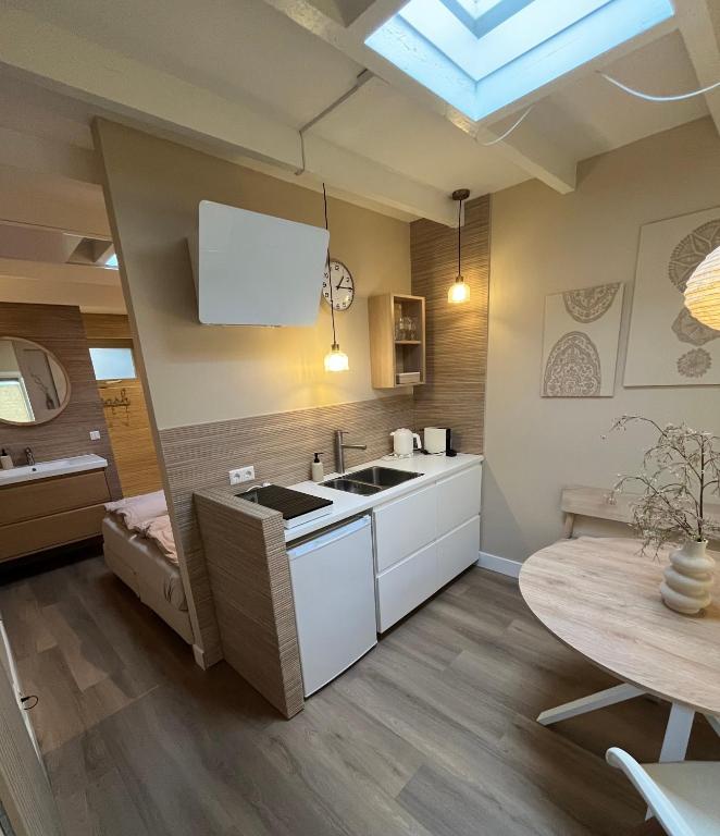 a kitchen with a sink and a table at Studio Oranje Nassau aan Zee in Zandvoort