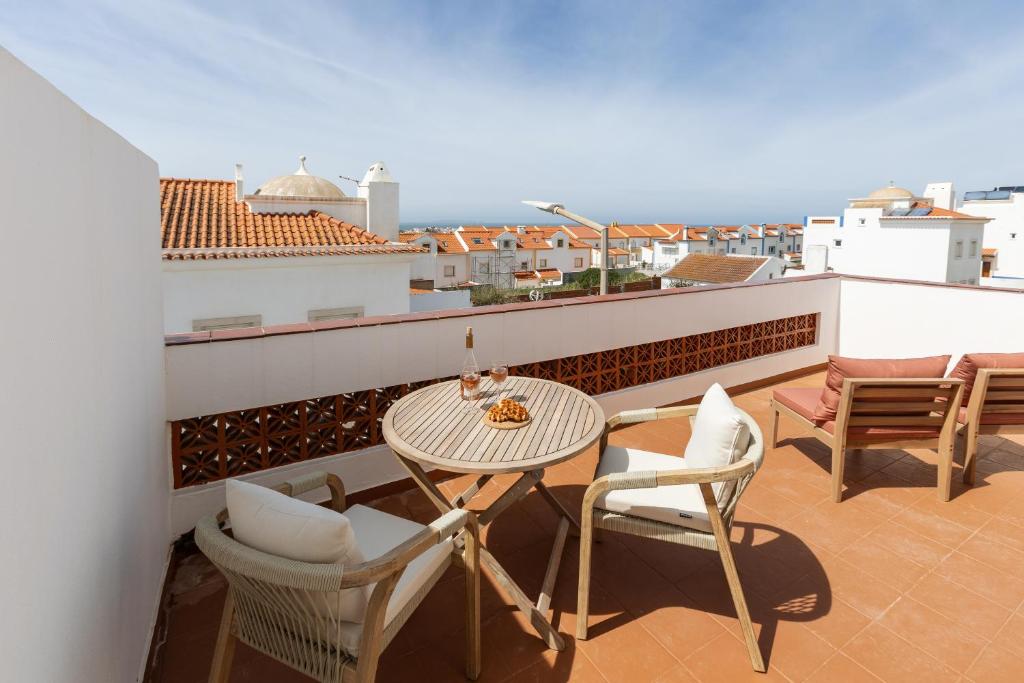 a patio with a table and chairs on a balcony at Casa da Shaka Baleal in Ferrel