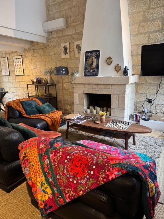 a living room with a couch and a fireplace at Chez Marie & Nico in Aigues-Mortes