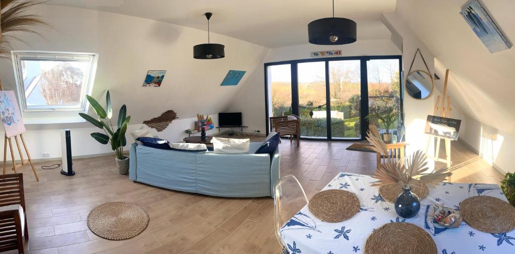a living room with a couch and a table at Rose et violette in Brélès