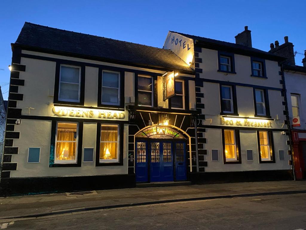 a black and white building with a blue door at The Queen's Head Hotel in Buxton