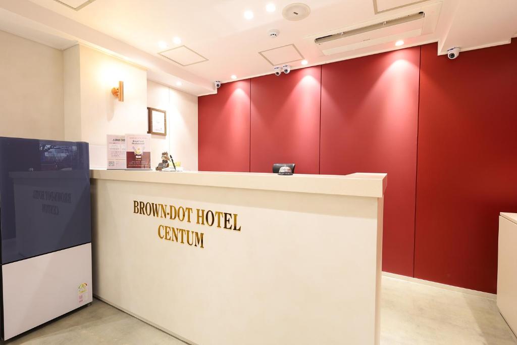 a reception counter in a room with red walls at 브라운도트호텔 센텀시티 벡스코점 in Busan