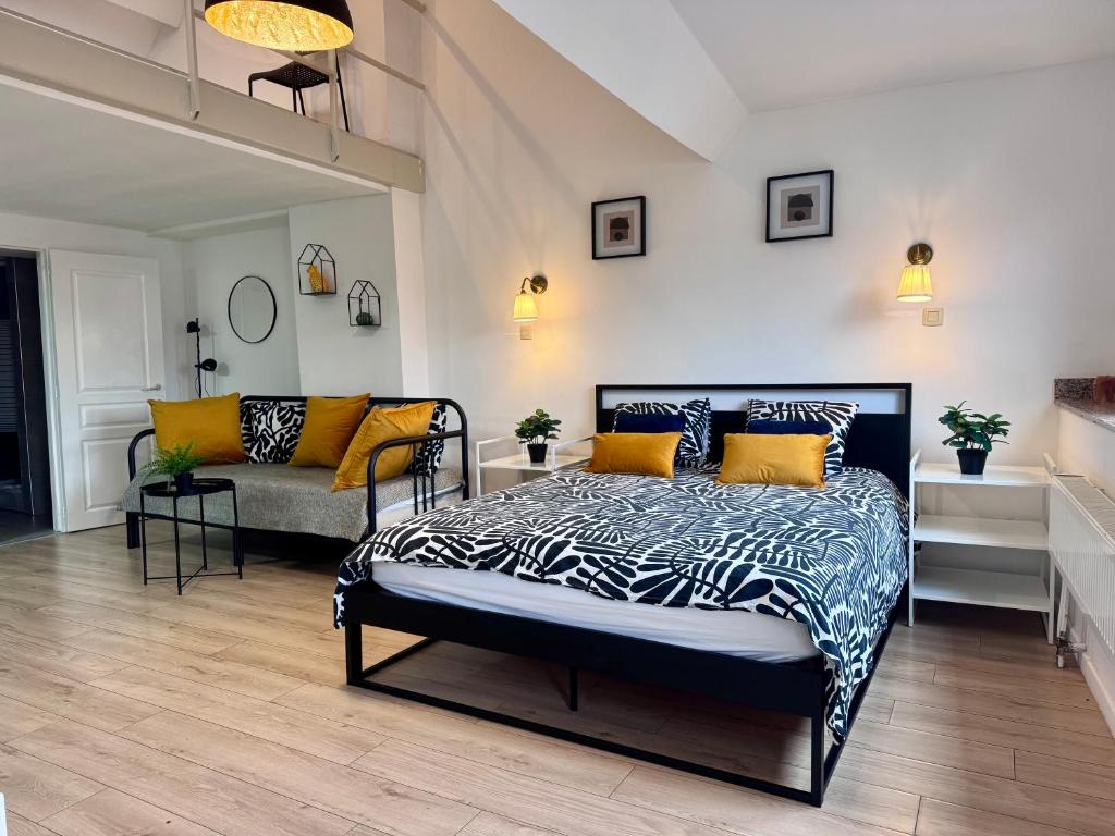a bedroom with a black and white bed and a couch at Sint-Jans Appartments in Antwerp