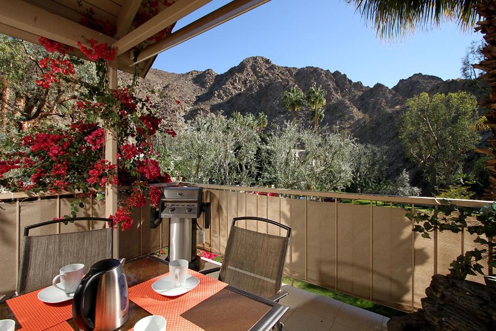 a table and chairs on a balcony with mountains in the background at Mountain Cove Private Condo in Indian Wells
