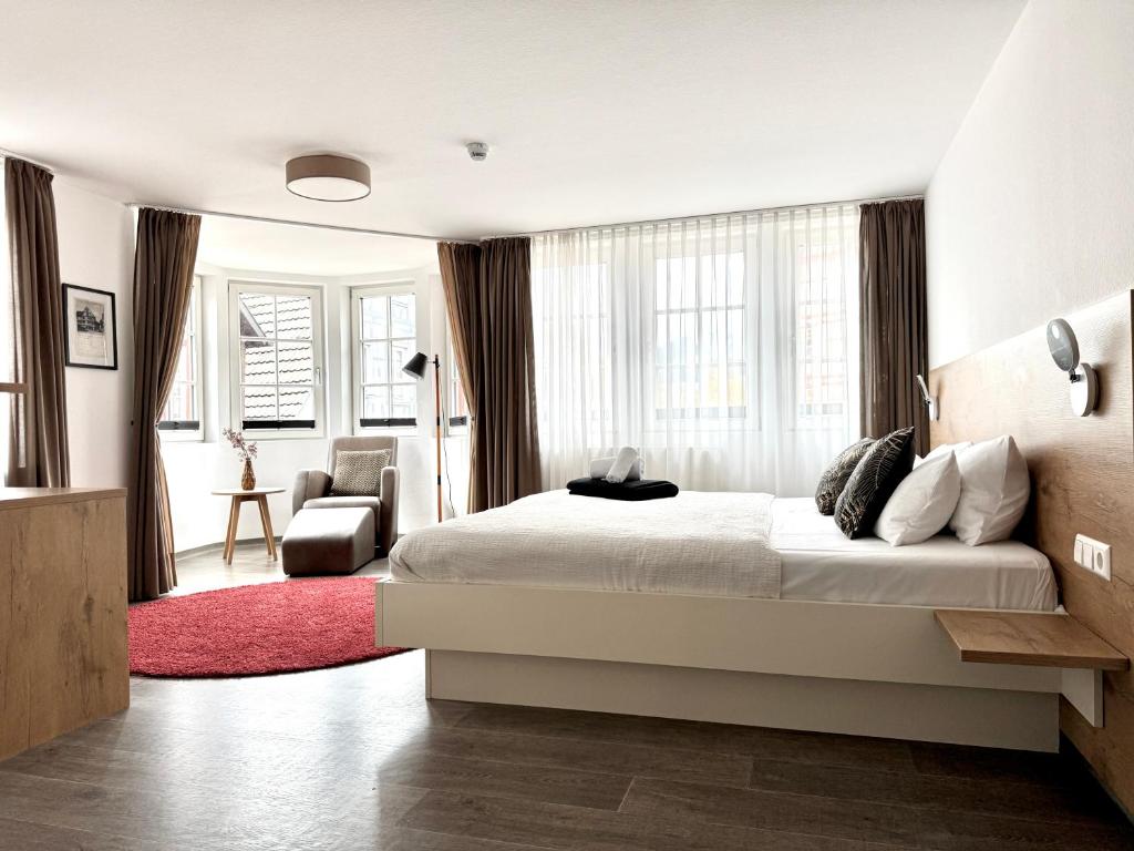 a bedroom with a bed and a red rug at Adler Hotel und Restaurant Schiltach in Schiltach