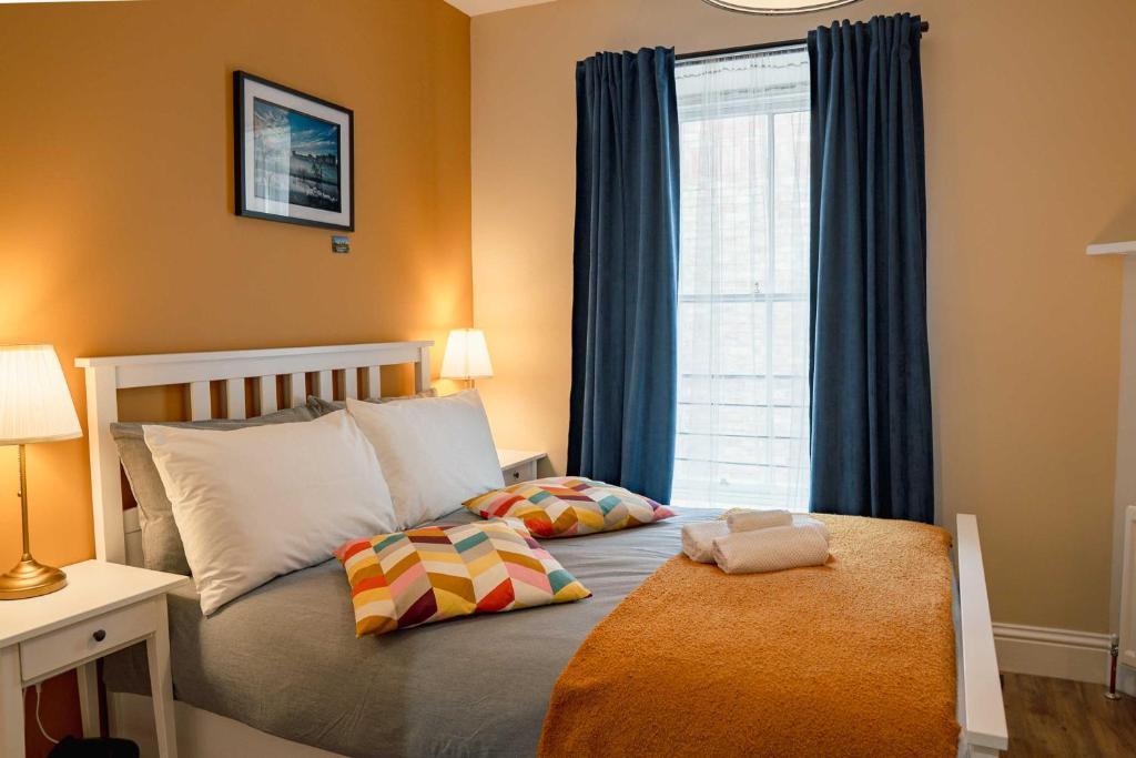 ein Schlafzimmer mit einem Bett mit zwei Kissen und einem Fenster in der Unterkunft 32 Bondgate Without in Alnwick