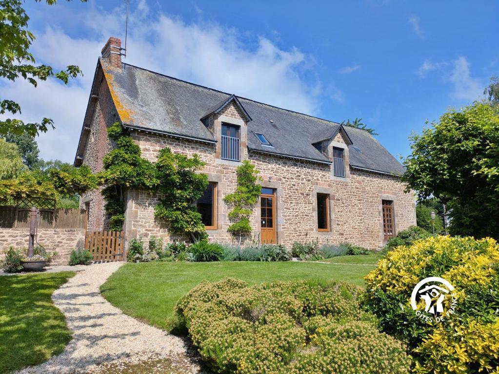 an old stone house with a garden in front of it at La grande reignière in Brécé