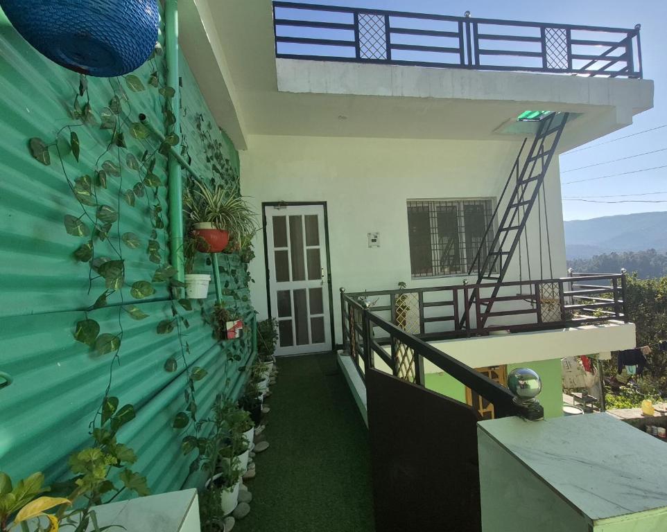 a house with a green wall and a staircase at Roaming Rovers - Pet-Friendly & Peaceful Homestay in Almora in Almora