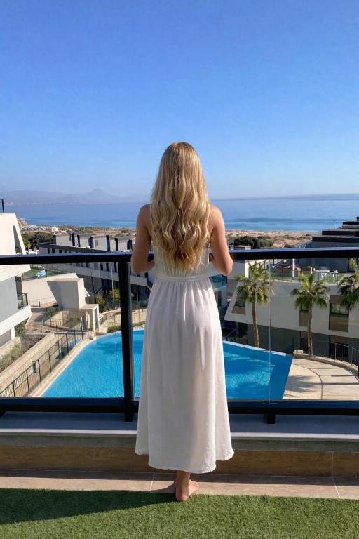 a little girl standing on a balcony looking at the ocean at Iconic Sea View in Gran Alacant