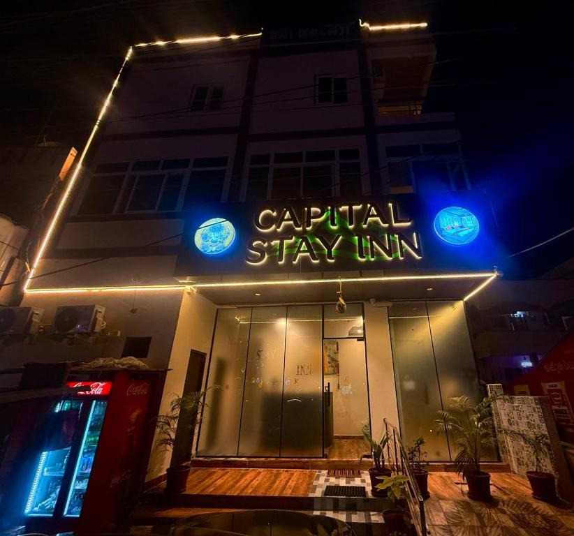 a building with a sign that readscapital stay units at night at Capital Stay Inn in Vijayawāda