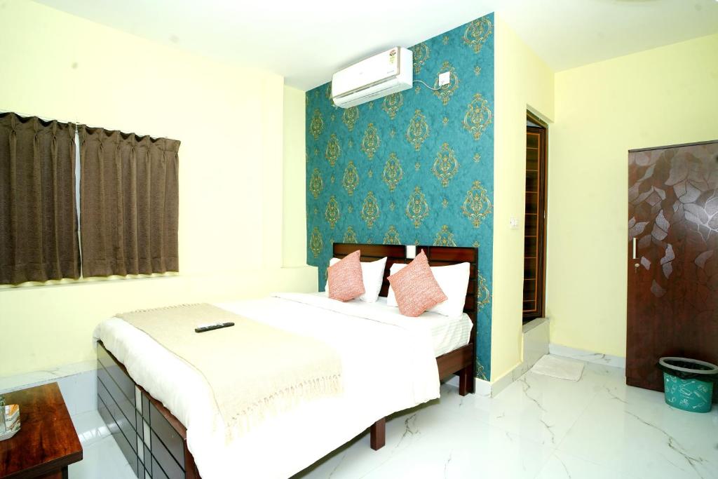 a bedroom with two beds and a blue wall at Sri Sai comforts - Bannerghatta Main Road in Bangalore