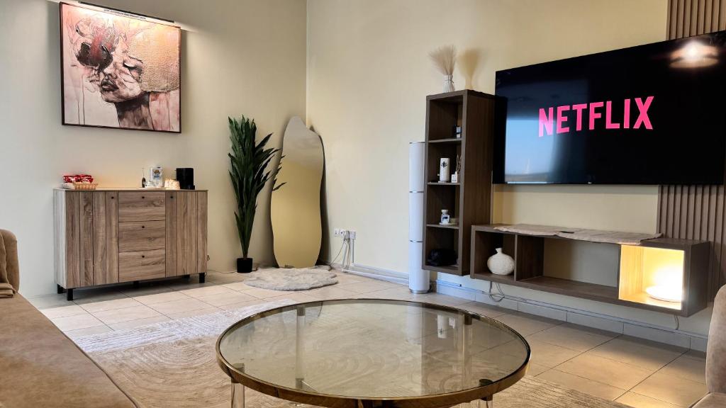 a living room with a tv and a glass table at Spacious 2BR Apartment,3 Bathrooms, Near Mall in Abu Dhabi