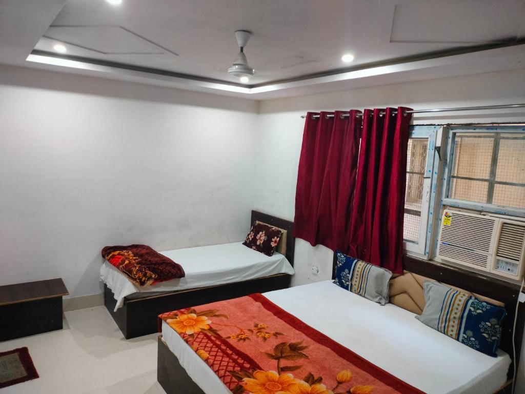 a room with two beds and a red curtain at Hotel Neelkanth in Vrindāvan
