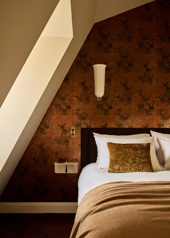 a bedroom with a bed with a red wall at L'Opale Noire in Paris