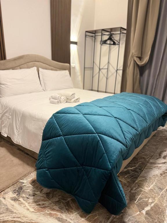 a blue blanket on a bed in a bedroom at DyAndy Suites Expo Milano in Baranzate