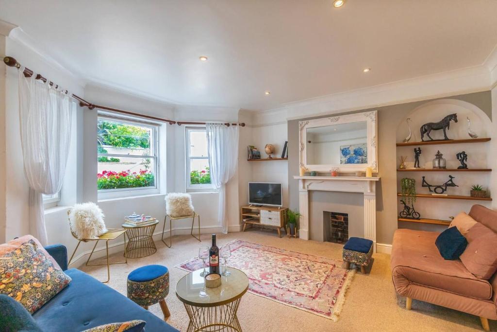 a living room with a blue couch and a fireplace at Spacious Seafront Apartment, Garden Free Parking in Littlehampton