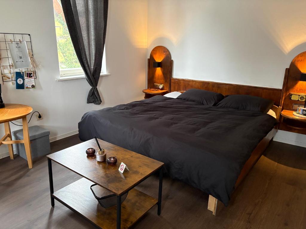 a bedroom with a large bed and a table at Junges Wohnen zwei in Weikersheim
