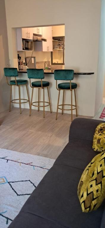 a room with four chairs and a counter with a kitchen at 3C Palm Ridge Vipingo in Kilifi