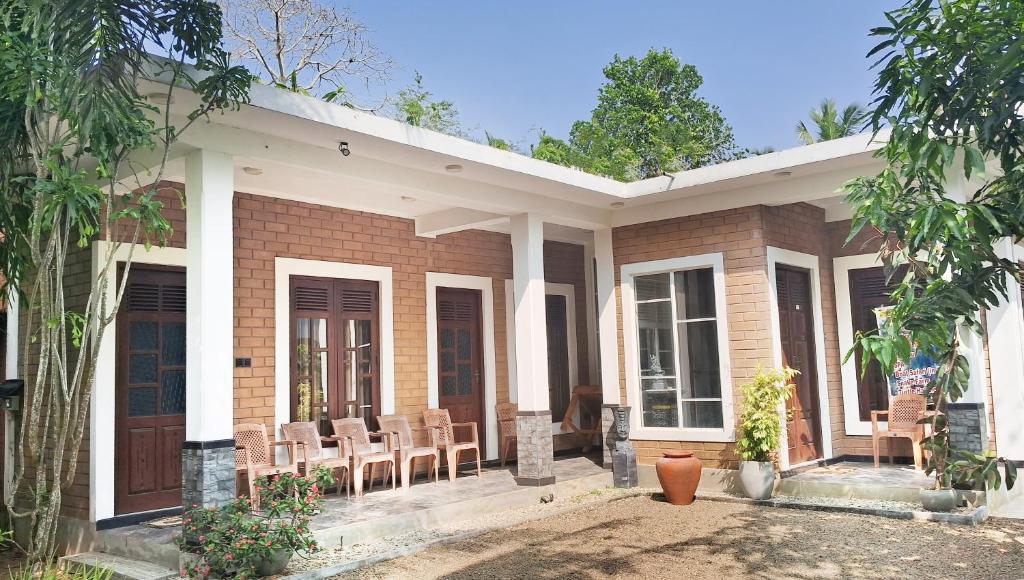 a brick house with chairs and tables in front of it at Villa Sol in Kamburugamuwa