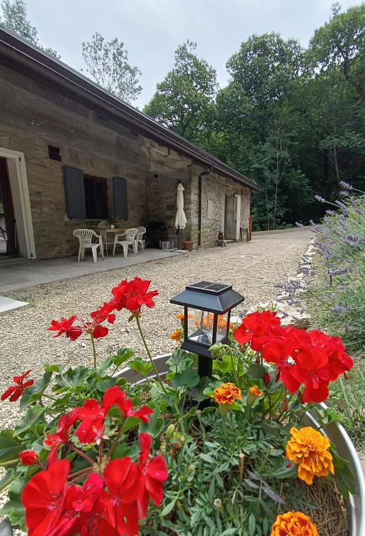 a garden with red flowers in front of a building at La Caserma -The Barracks in Bobbio Pellice