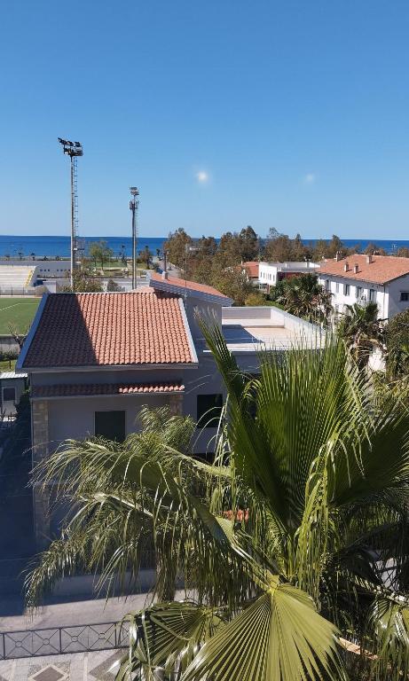 a palm tree in front of a building at Mira Beach Casa Vacanze in Praia a Mare